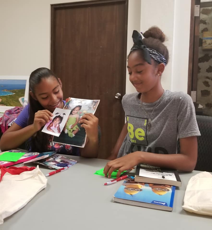 Photo of two "Oral Histories for Community Archives" workshop participants sharing early childhood pictures at Fundación Culebra (2018)